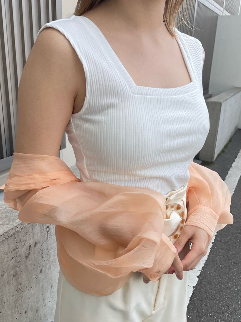 ホワイト系のスラックス、ホワイト系のハンドバッグ、ホワイト系のタンクトップを着用したレディースの春コーディネートの7枚目の写真