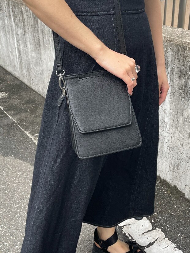 ブラック系のワンピース、ブラック系のサンダル、ブラック系のハンドバッグを着用したレディースの春コーディネートの7枚目の写真