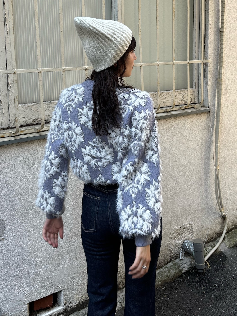 パープル系のニット/セーター、ブルー系のブルゾン、ブルー系のデニムパンツを着用したレディースの秋コーディネートの6枚目の写真