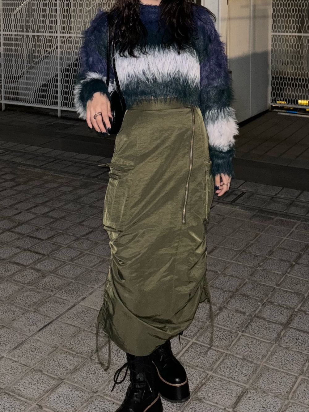 ブルー系のニット/セーター、グリーン系のスカートを着用したレディースの冬コーディネートの2枚目の写真