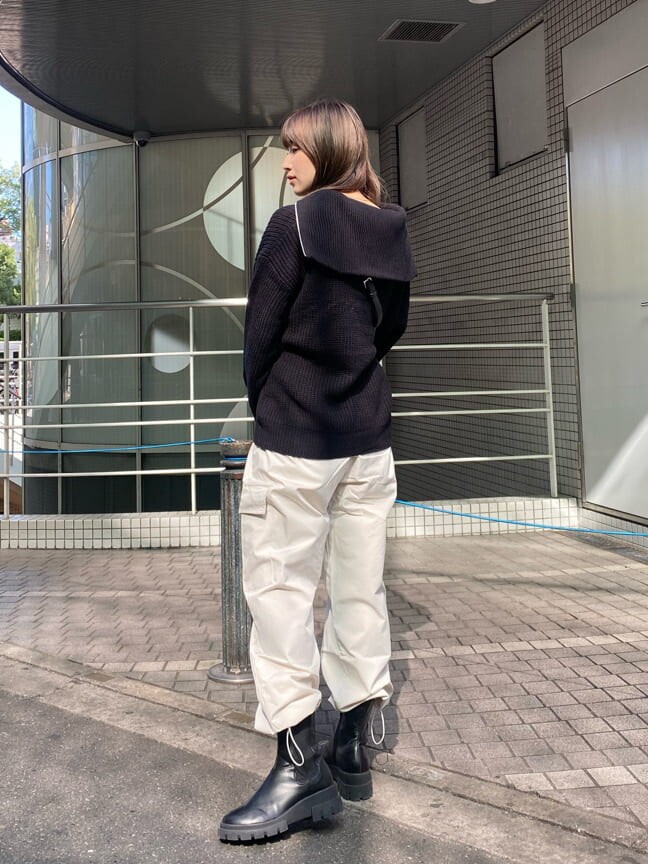 ブラック系のブーツ、ブラック系のニット/セーター、ブラック系のショルダーバッグを着用したレディースの秋コーディネートの3枚目の写真