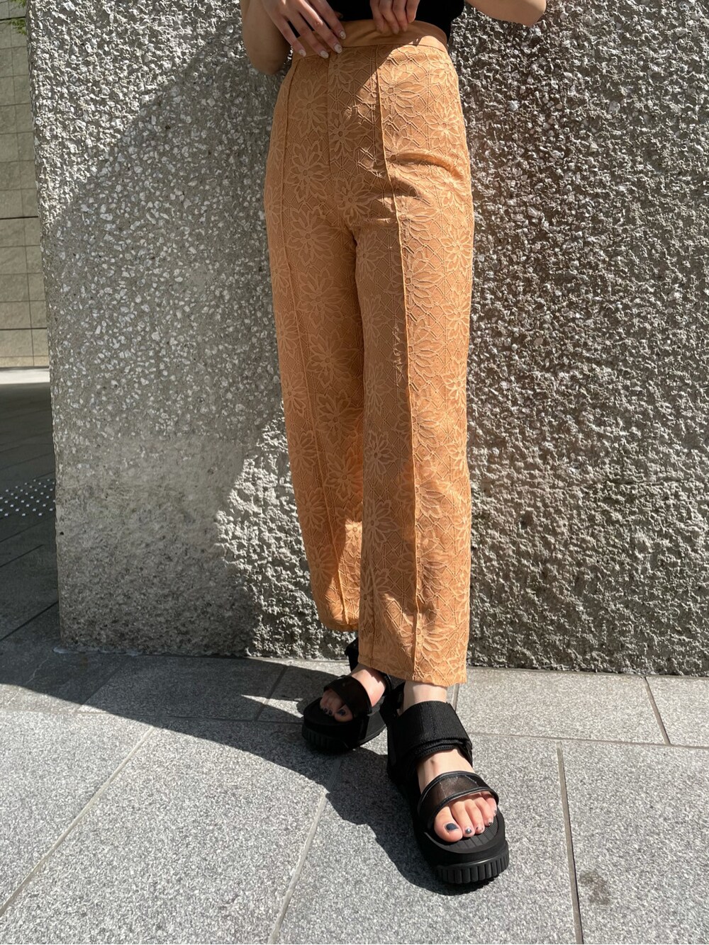 オレンジ系のその他パンツ、ブラック系のサンダル、ブラック系のニット/セーターを着用したレディースの春コーディネートの5枚目の写真