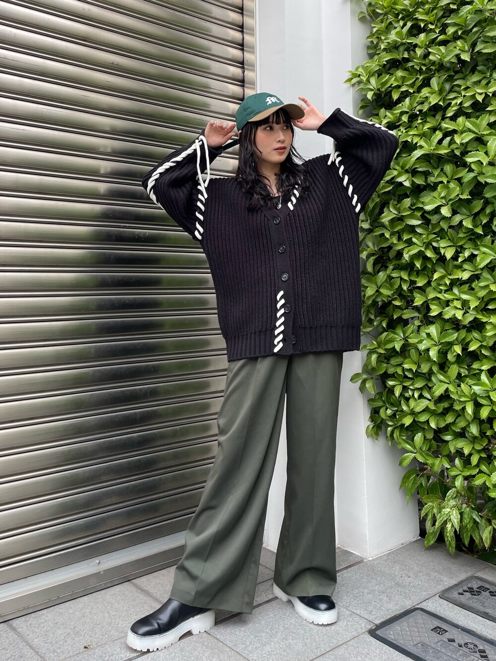 ベージュ系のスラックス、ブラック系のカーディガン/ボレロ、グリーン系のキャップを着用したレディースの秋コーディネートの7枚目の写真