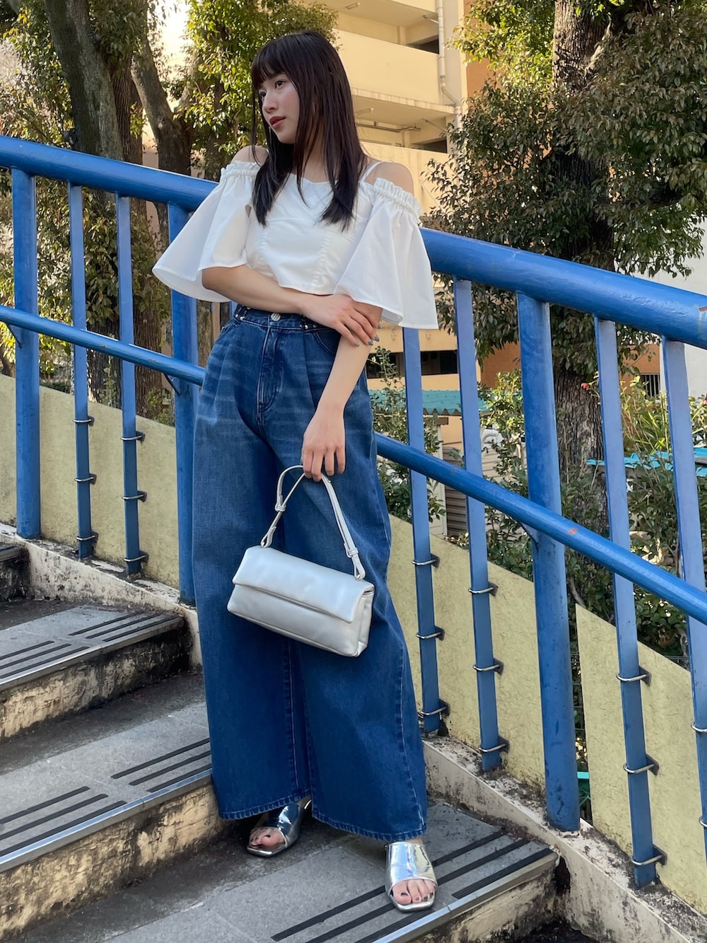 ホワイト系のシャツ/ブラウス、ブルー系のデニムパンツを着用したレディースの夏コーディネートの2枚目の写真