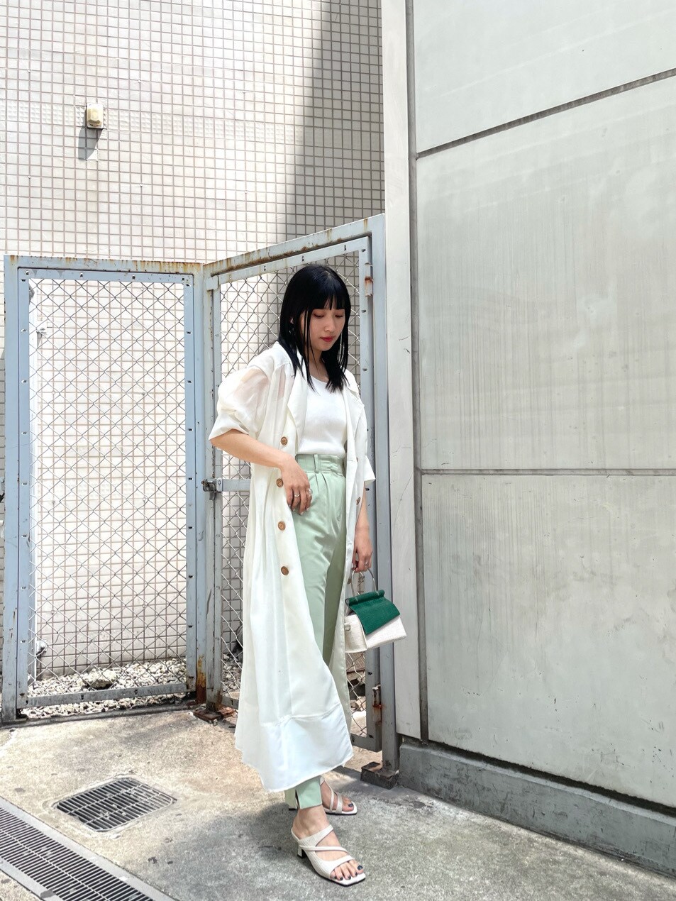 グリーン系のその他パンツ、ホワイト系のトレンチコート、ホワイト系のサンダルを着用したレディースの春コーディネートの4枚目の写真