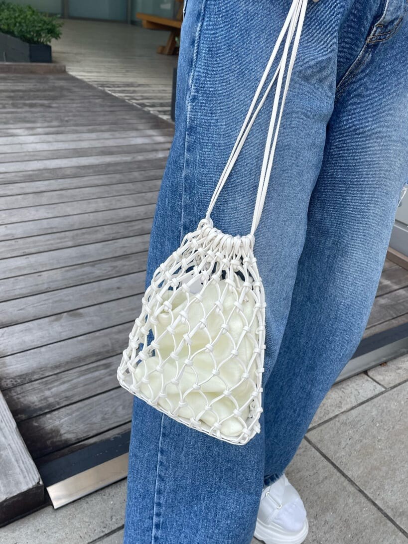 ホワイト系のサンダル、ホワイト系のハンドバッグ、グリーン系のポロシャツを着用したレディースの春コーディネートの7枚目の写真