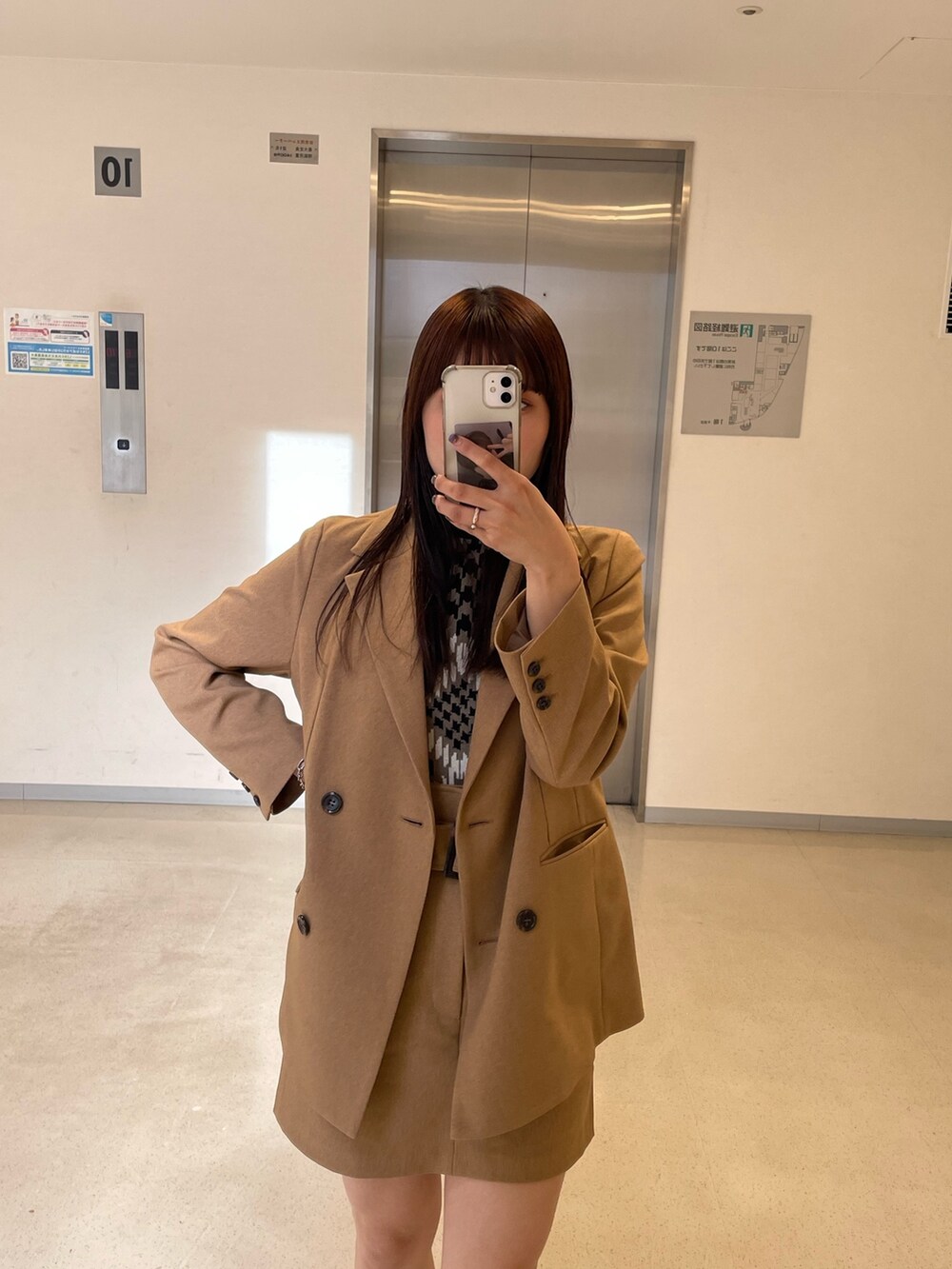 ベージュ系のスカート、グレー系のテーラードジャケットを着用したレディースの秋コーディネートの2枚目の写真