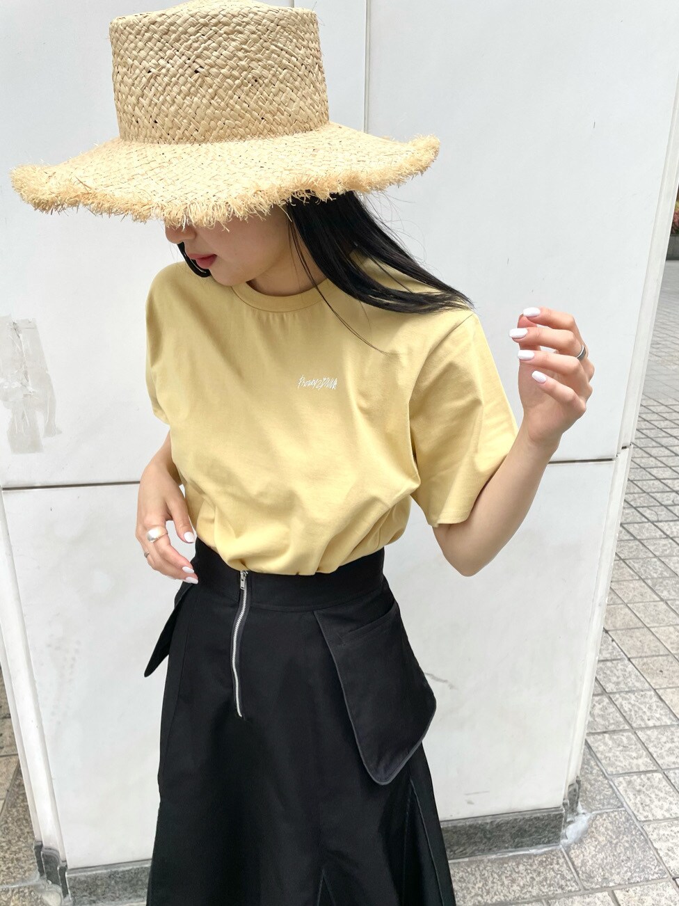 ブラック系のスカート、ブラック系のサンダル、イエロー系のTシャツ/カットソーを着用したレディースの春コーディネートの6枚目の写真