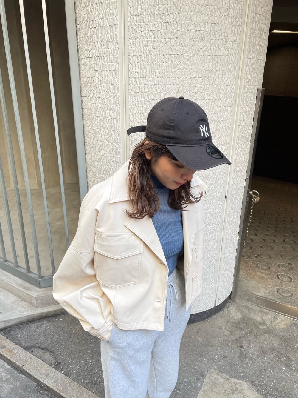 ブルー系のニット/セーター、ホワイト系のライダースジャケットを着用したレディースの冬コーディネートの4枚目の写真