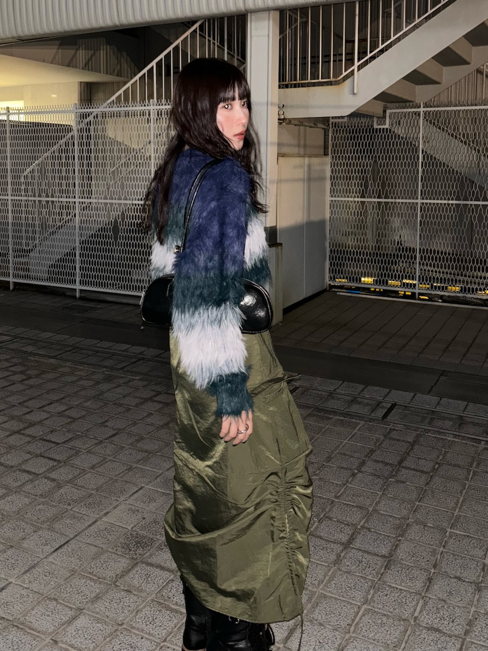 ブルー系のニット/セーター、グリーン系のスカートを着用したレディースの冬コーディネートの3枚目の写真