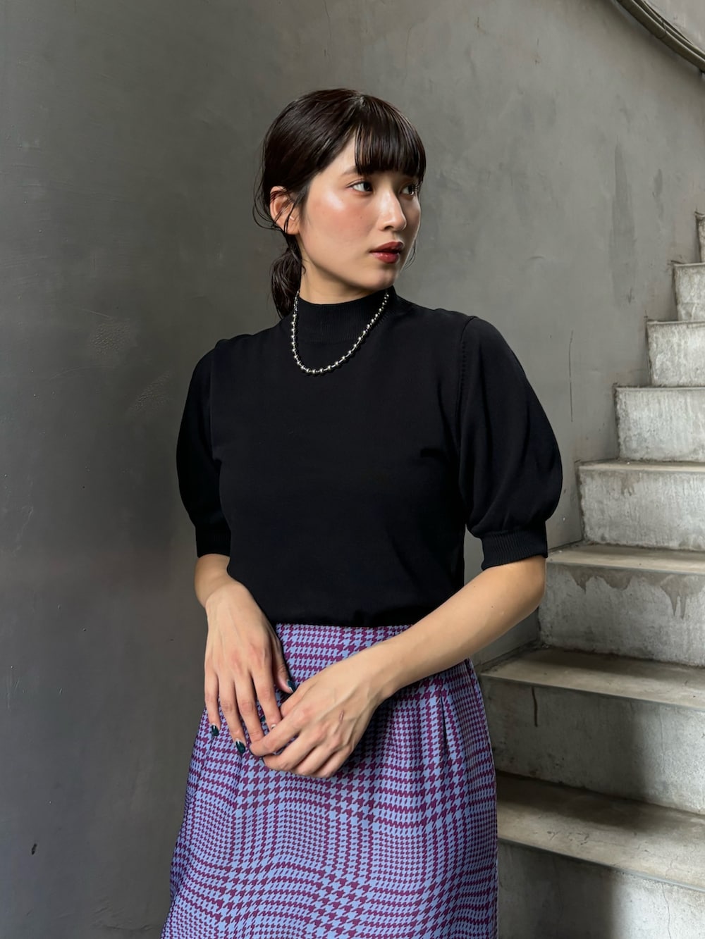 ブラック系のニット/セーター、パープル系のスカートを着用したレディースの夏コーディネートの4枚目の写真