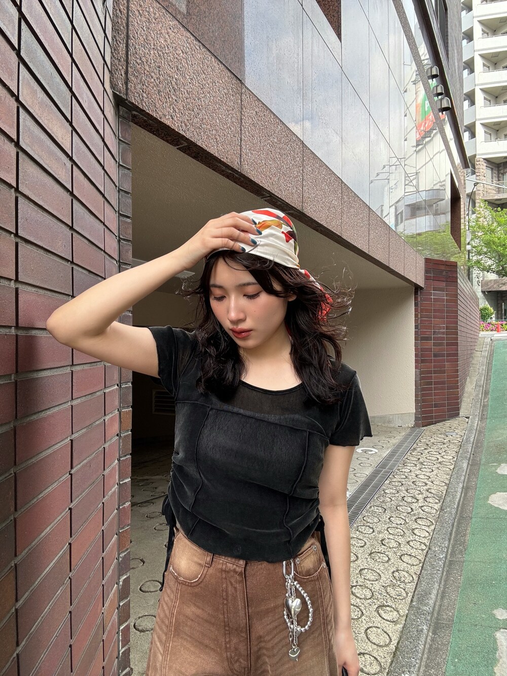 ブラウン系のデニムパンツ、ブラック系のサンダル、オレンジ系のバンダナ/スカーフを着用したレディースの春コーディネートの5枚目の写真