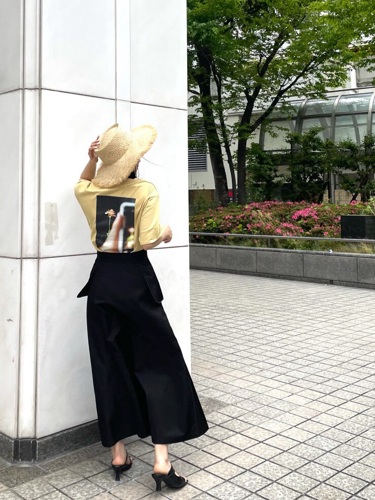 ブラック系のスカート、ブラック系のサンダル、イエロー系のTシャツ/カットソーを着用したレディースの春コーディネートの3枚目の写真