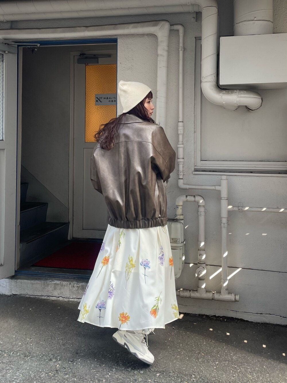 ホワイト系のワンピース、ブラウン系のブルゾンを着用したレディースの冬コーディネートの3枚目の写真