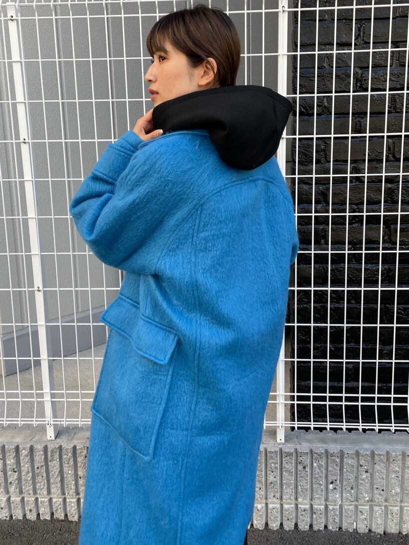 ブラック系のブーツ、ブラック系のパーカー、ブルー系のチェスターコートを着用したレディースの秋コーディネートの5枚目の写真