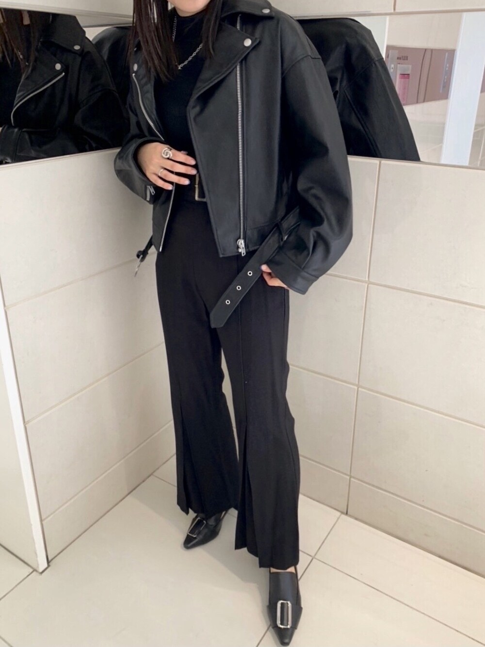 ブラック系のその他パンツ、ブラック系のパンプス、ブラック系のライダースジャケットを着用したレディースの冬コーディネートの3枚目の写真