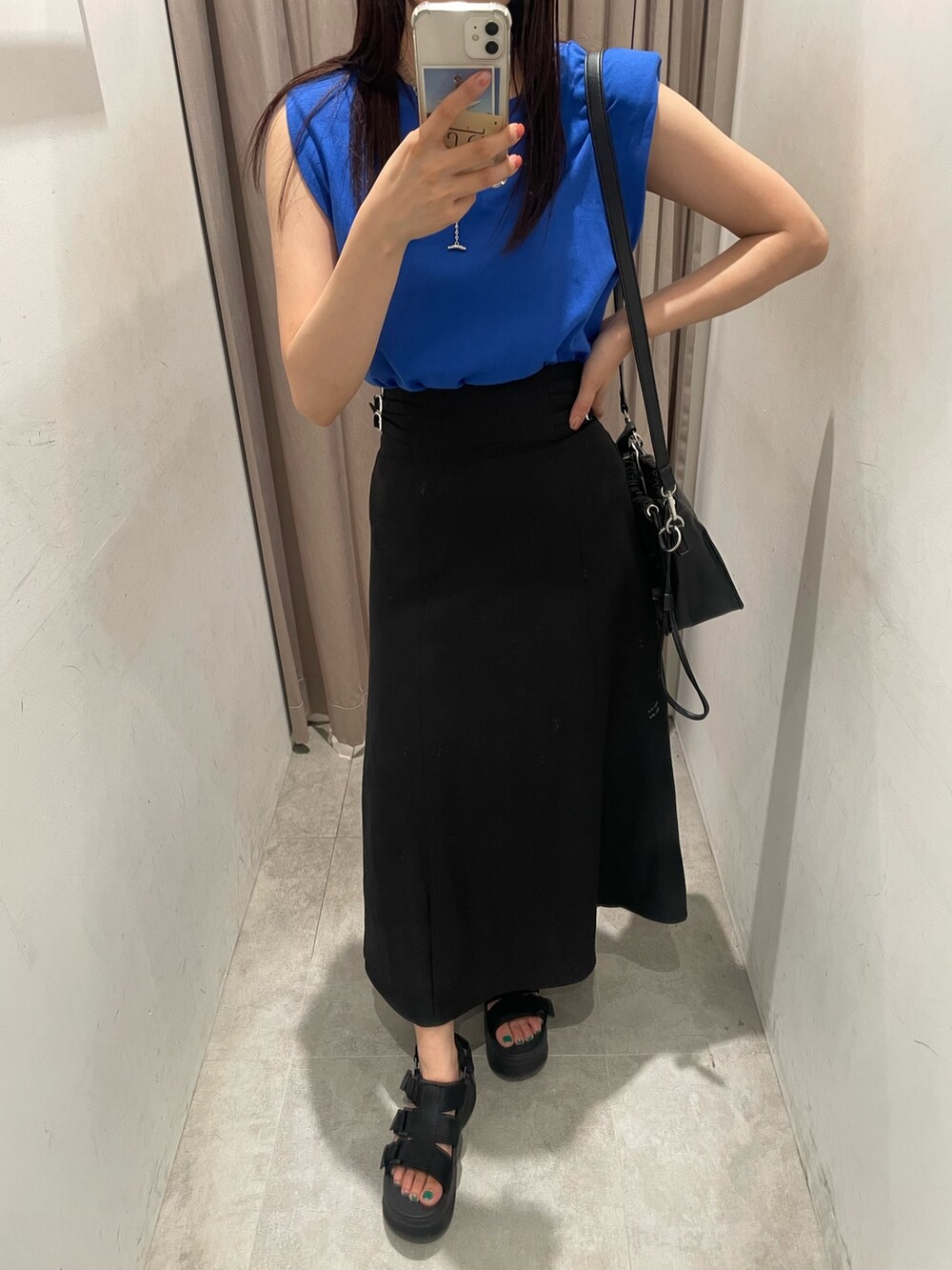ブラック系のスカート、ブルー系のTシャツ/カットソーを着用したレディースの夏コーディネートの2枚目の写真