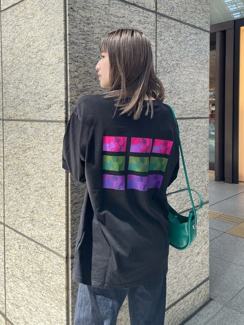 グリーン系のハンドバッグ、ブラック系のブーツ、ブラック系のTシャツ/カットソーを着用したレディースの夏コーディネートの7枚目の写真