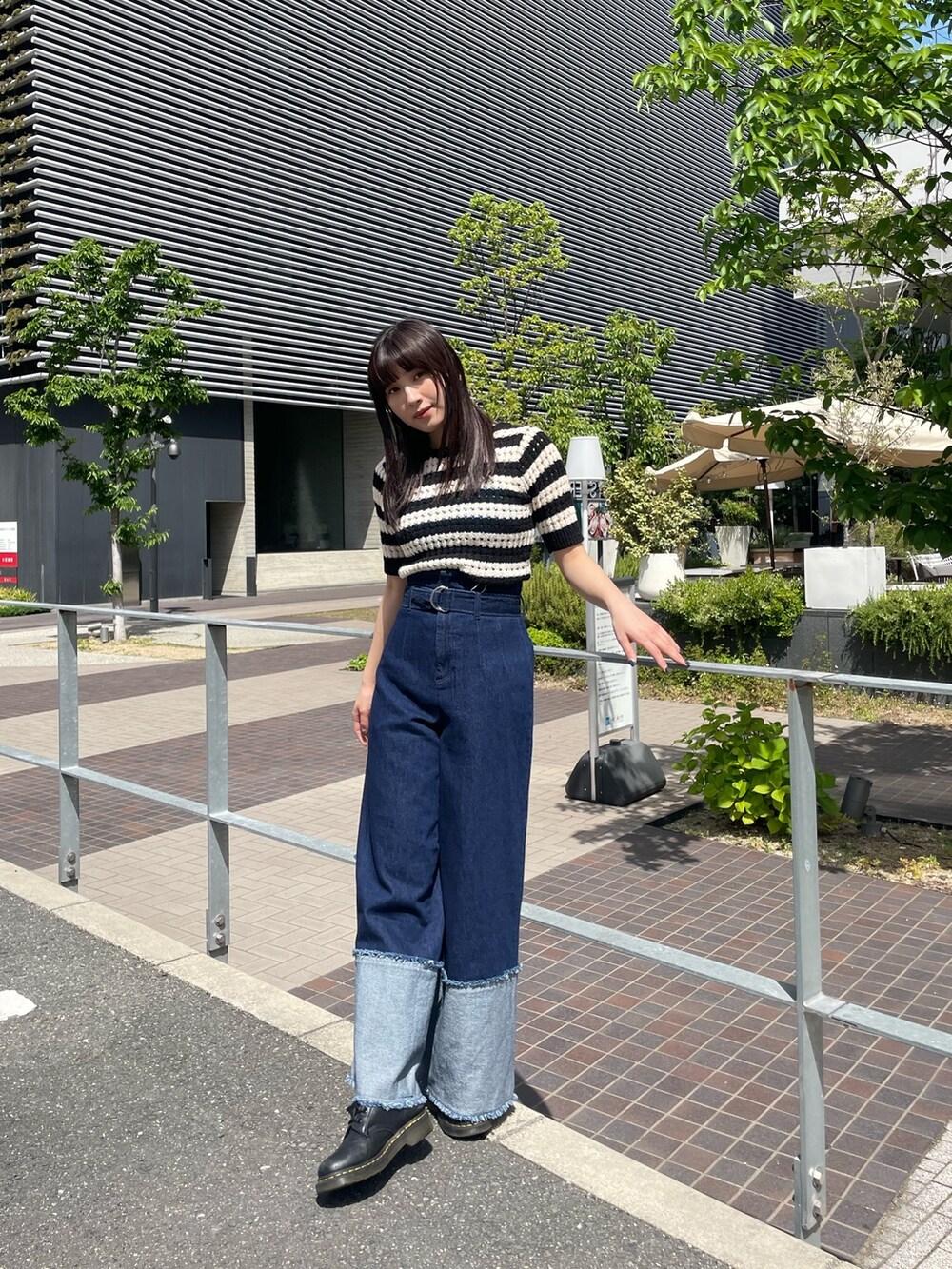 ブルー系のデニムパンツ、ブルー系のTシャツ/カットソー、ブラック系のニット/セーターを着用したレディースの春コーディネートの2枚目の写真