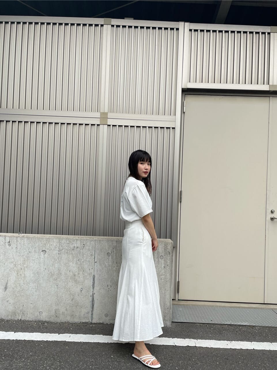 ホワイト系のスカート、ホワイト系のサンダル、ホワイト系のTシャツ/カットソーを着用したレディースの夏コーディネートの5枚目の写真
