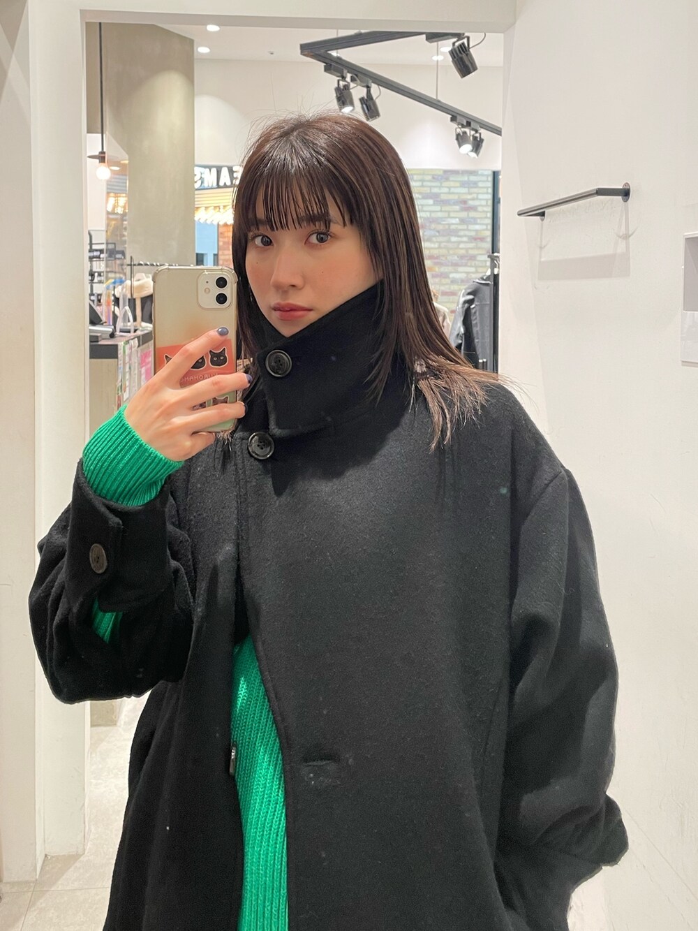 ブラック系のダウンジャケット/コート、グリーン系のニット/セーターを着用したレディースの冬コーディネートの5枚目の写真