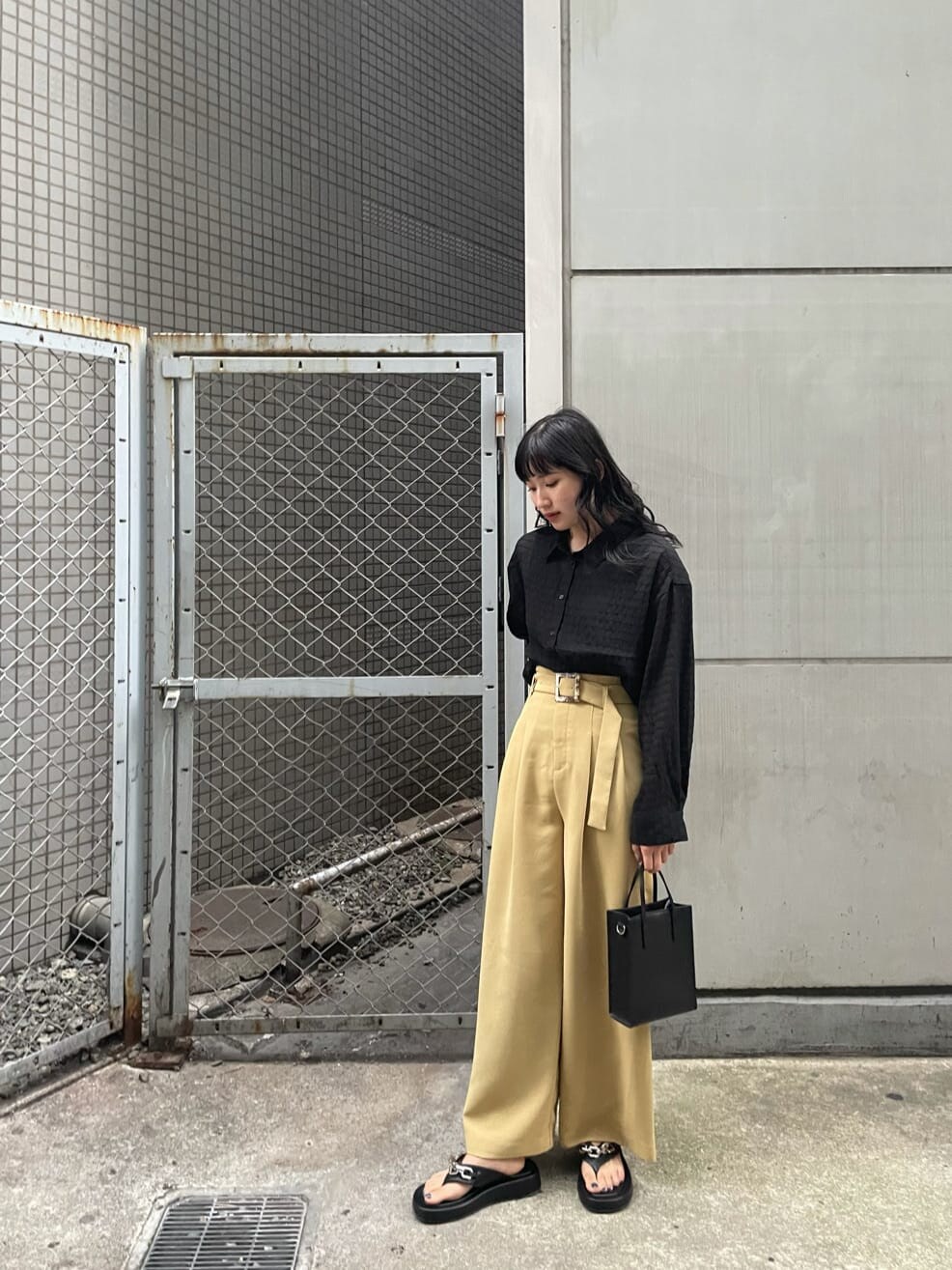 ブラック系のシャツ/ブラウス、イエロー系のその他パンツ、ブラック系のサンダルを着用したレディースの夏コーディネートの2枚目の写真