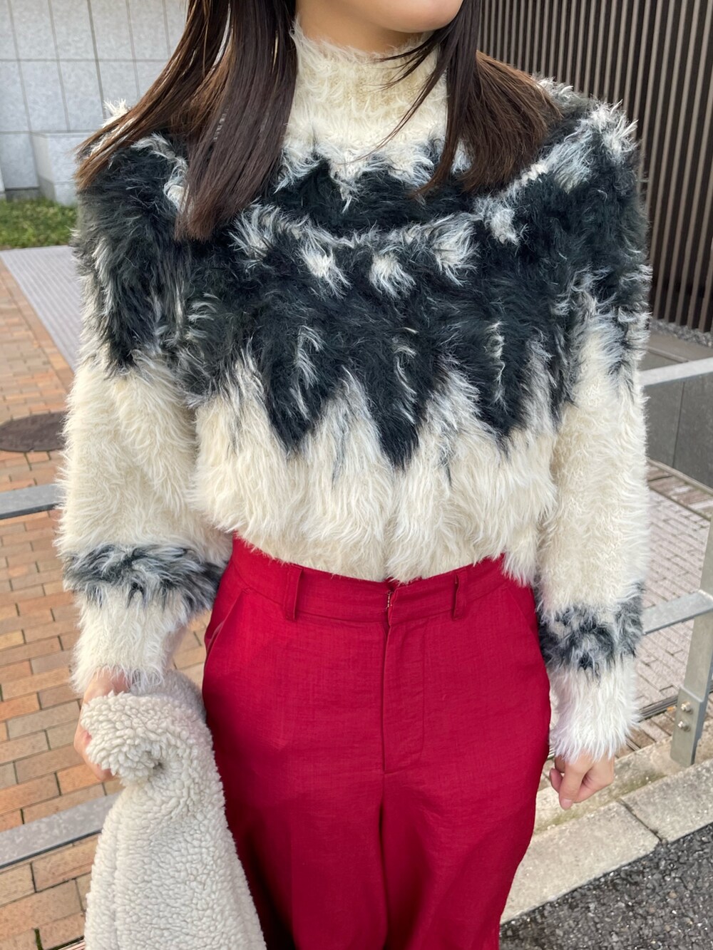 ホワイト系のニット/セーター、ブラウン系のムートンコートを着用したレディースの秋コーディネートの4枚目の写真