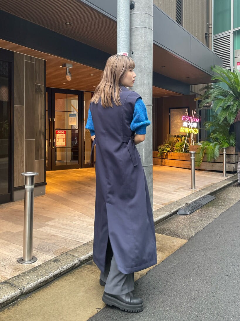 ブルー系のニット/セーター、ブルー系のトレンチコート、グレー系のスラックスを着用したレディースの秋コーディネートの4枚目の写真