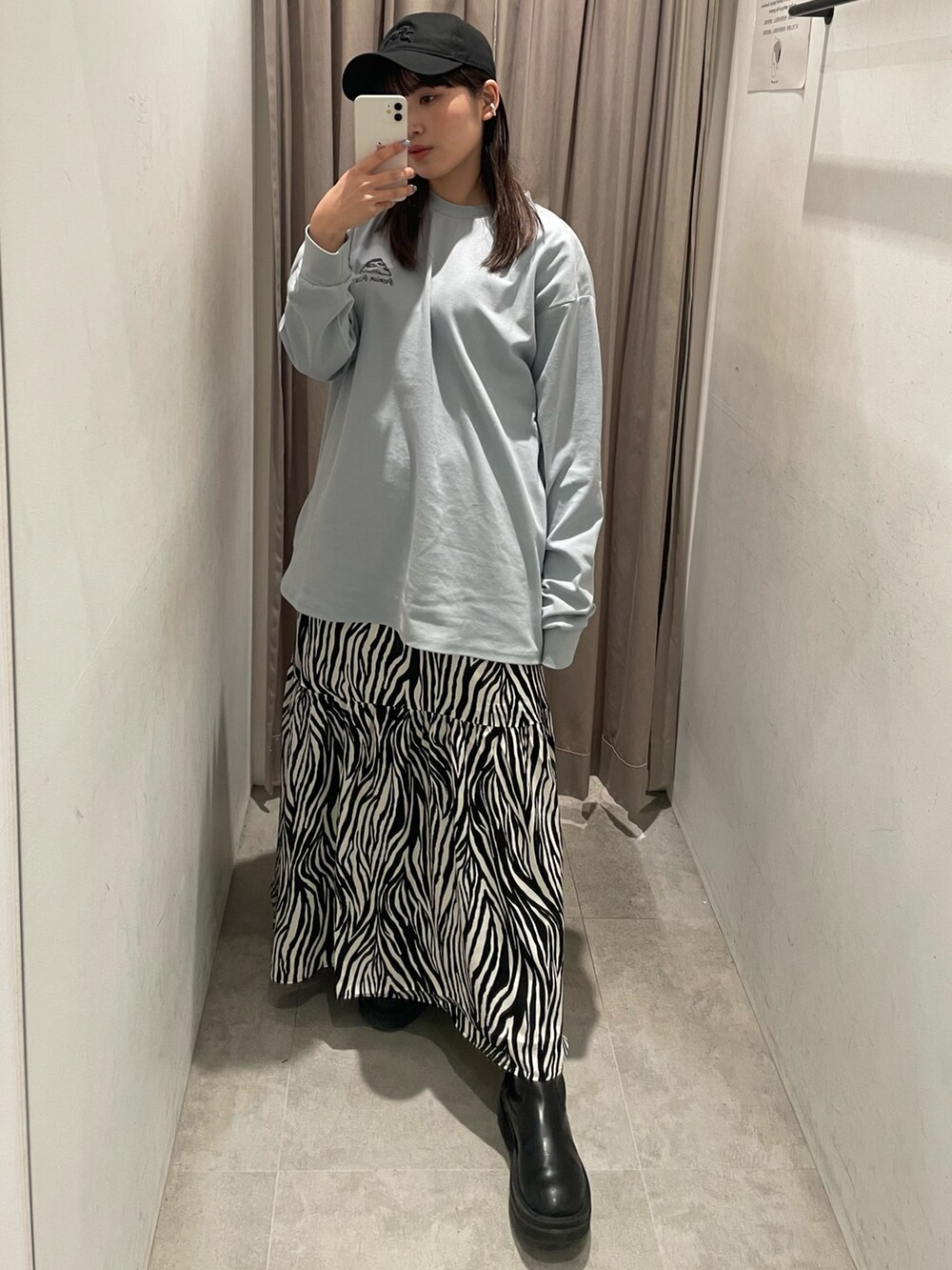 ホワイト系のスカート、ブルー系のTシャツ/カットソー、ブラック系のキャップを着用したレディースの冬コーディネートの3枚目の写真