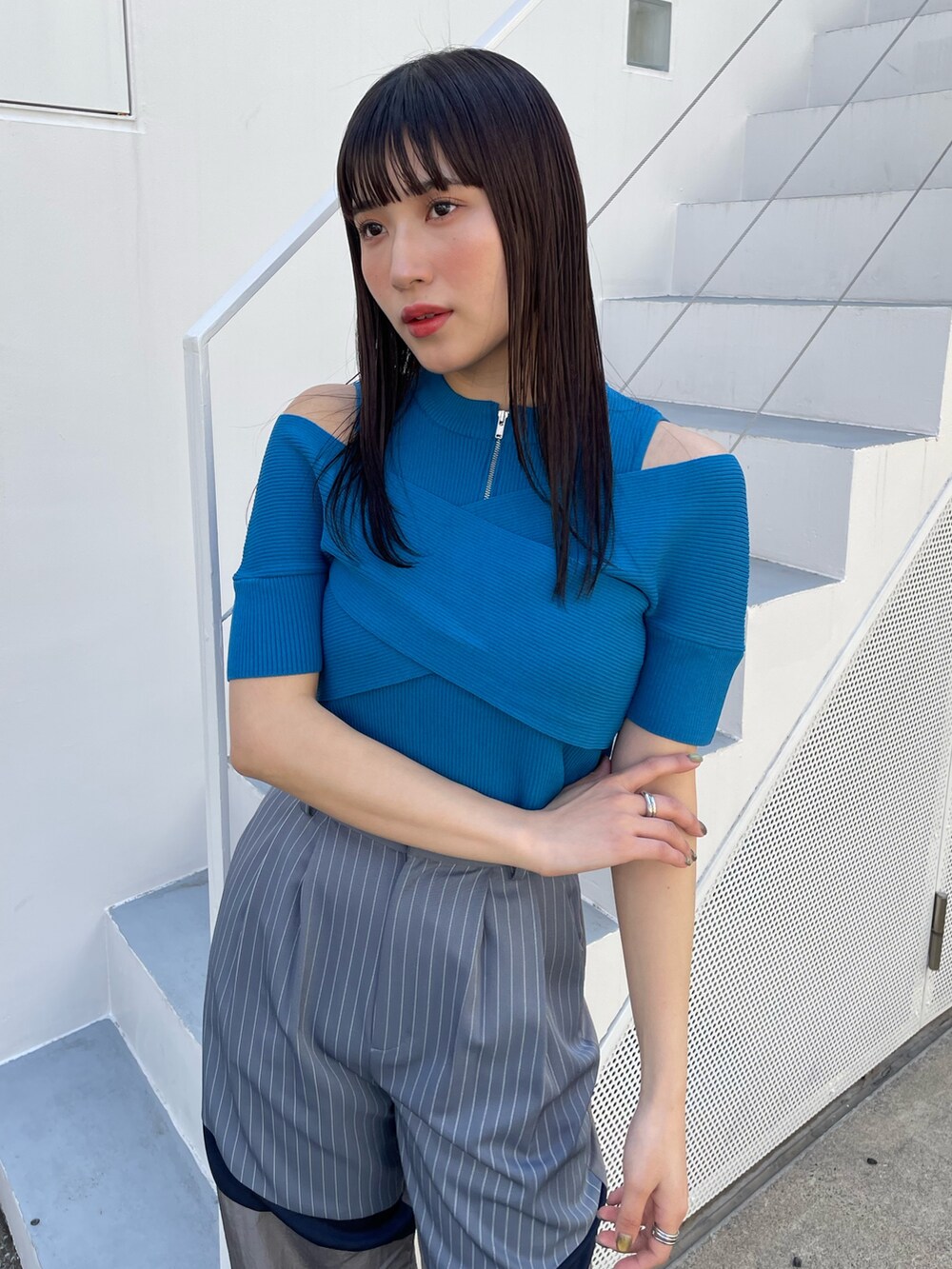 グレー系のその他パンツ、ブルー系のニット/セーターを着用したレディースの夏コーディネートの3枚目の写真