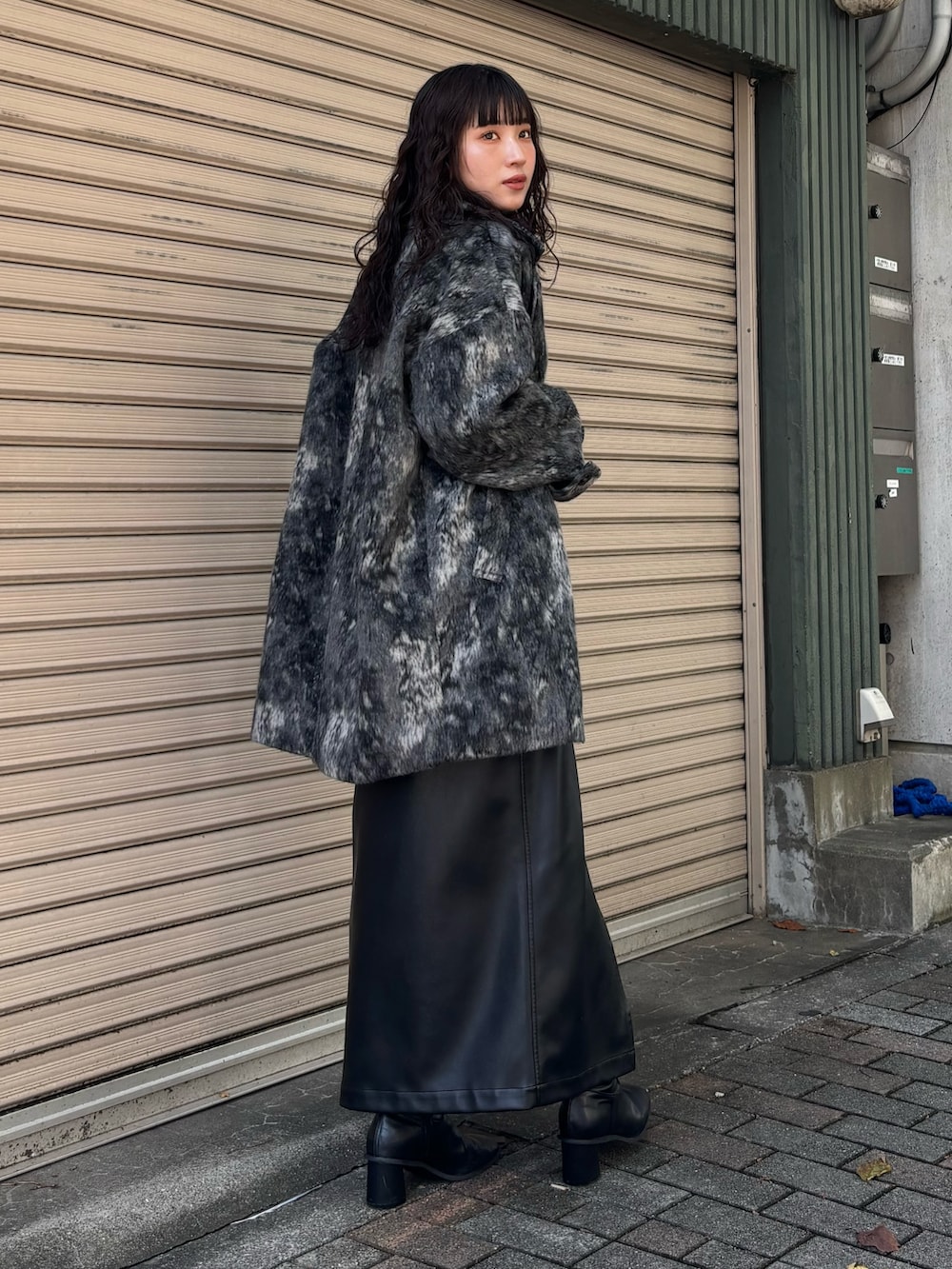 ブルー系のニット/セーター、ブラック系のその他アウター、ブラック系のスカートを着用したレディースの秋コーディネートの3枚目の写真