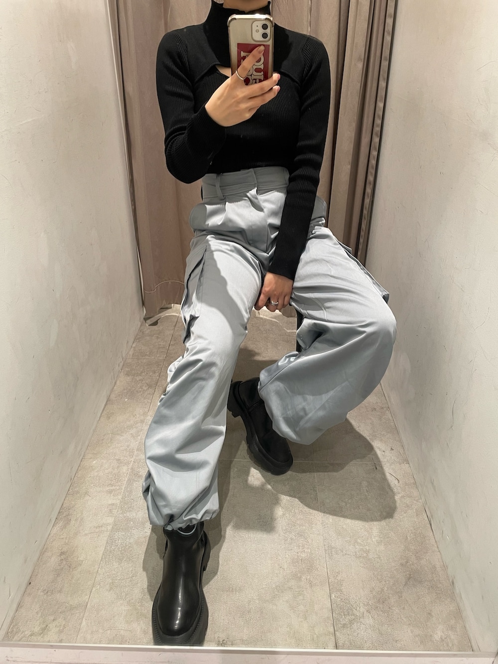 ブラック系のニット/セーター、ブルー系のカーゴパンツ、ブラック系のブーツを着用したレディースの冬コーディネートの5枚目の写真