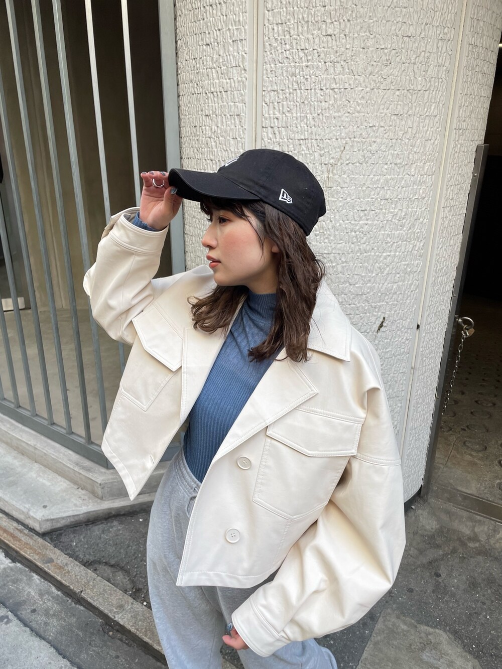 ブルー系のニット/セーター、ホワイト系のライダースジャケットを着用したレディースの冬コーディネートの3枚目の写真