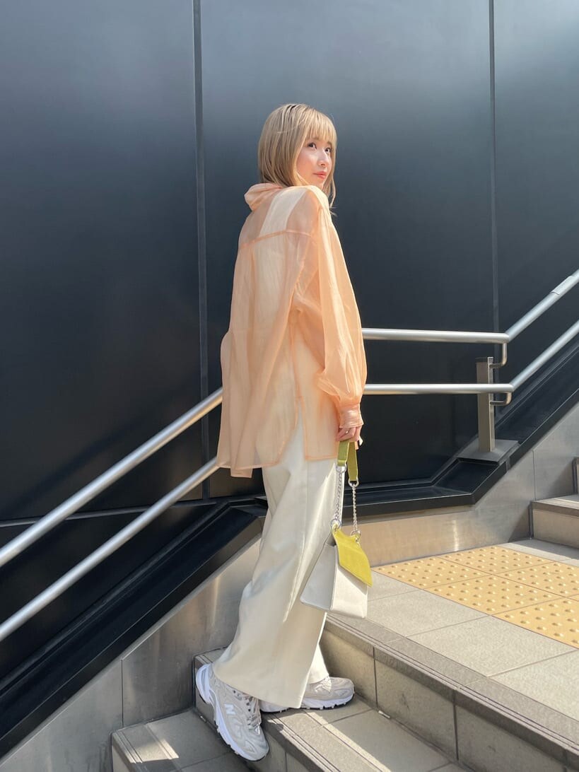 ホワイト系のスラックス、ホワイト系のハンドバッグ、ホワイト系のタンクトップを着用したレディースの春コーディネートの2枚目の写真