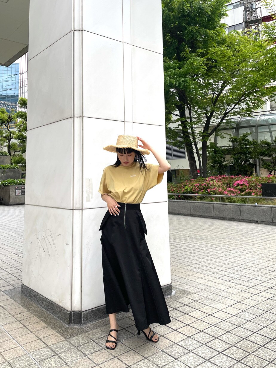 ブラック系のスカート、ブラック系のサンダル、イエロー系のTシャツ/カットソーを着用したレディースの春コーディネートの5枚目の写真