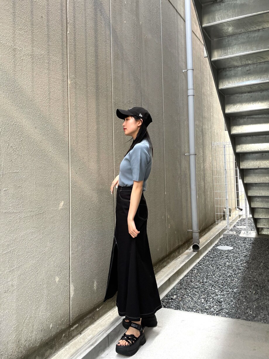 ブラック系のスカート、ブラック系のサンダル、ブルー系のニット/セーターを着用したレディースの春コーディネートの2枚目の写真