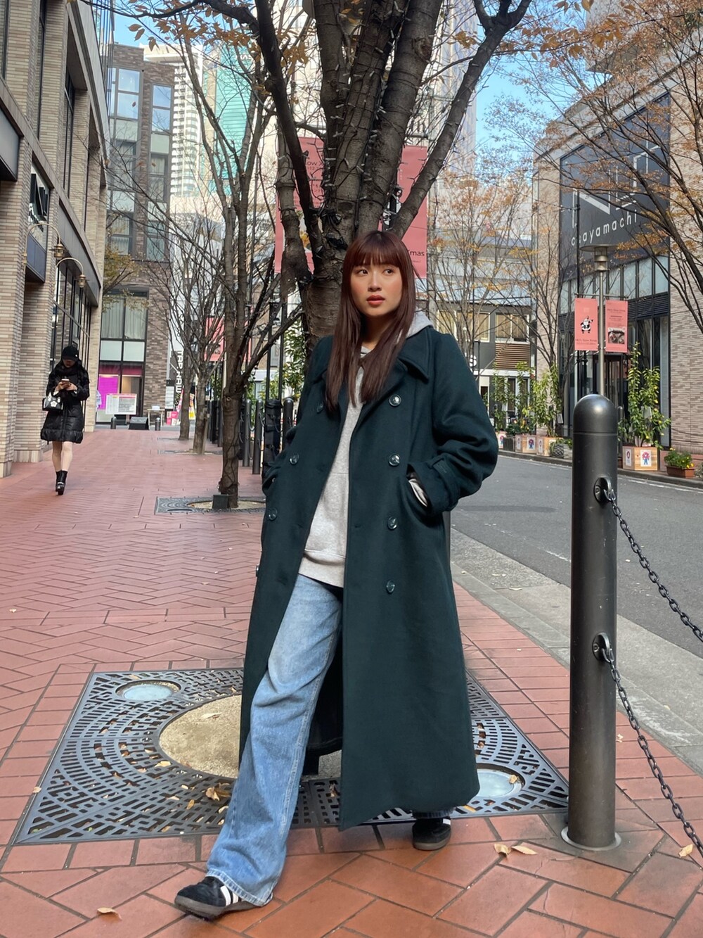 グリーン系のチェスターコートを着用したレディースの冬コーディネートの2枚目の写真
