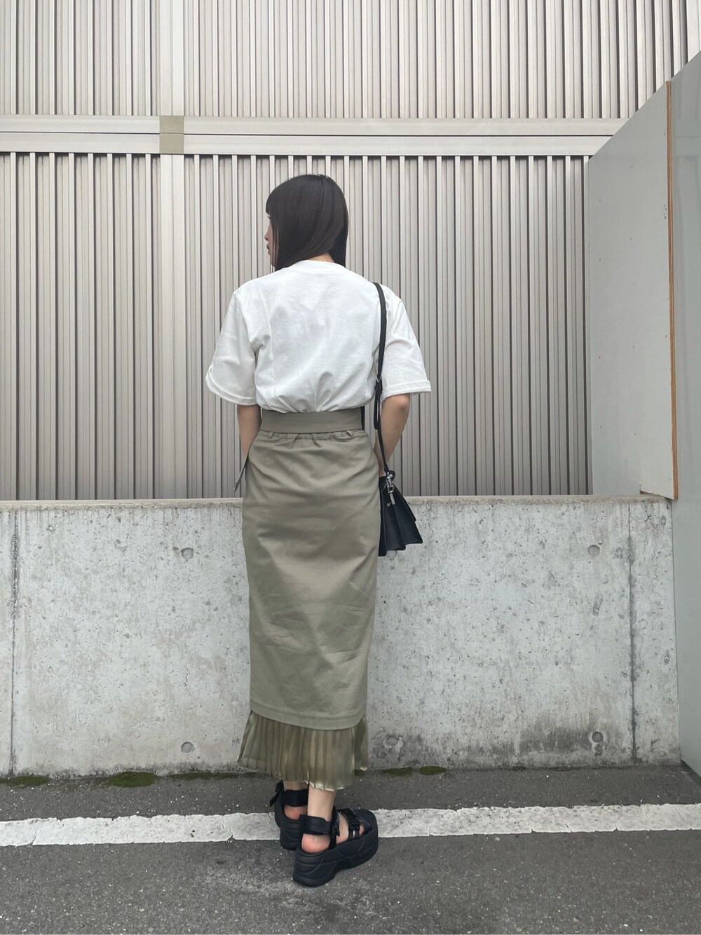 ベージュ系のスカート、ブラック系のサンダル、ホワイト系のTシャツ/カットソーを着用したレディースの春コーディネートの5枚目の写真