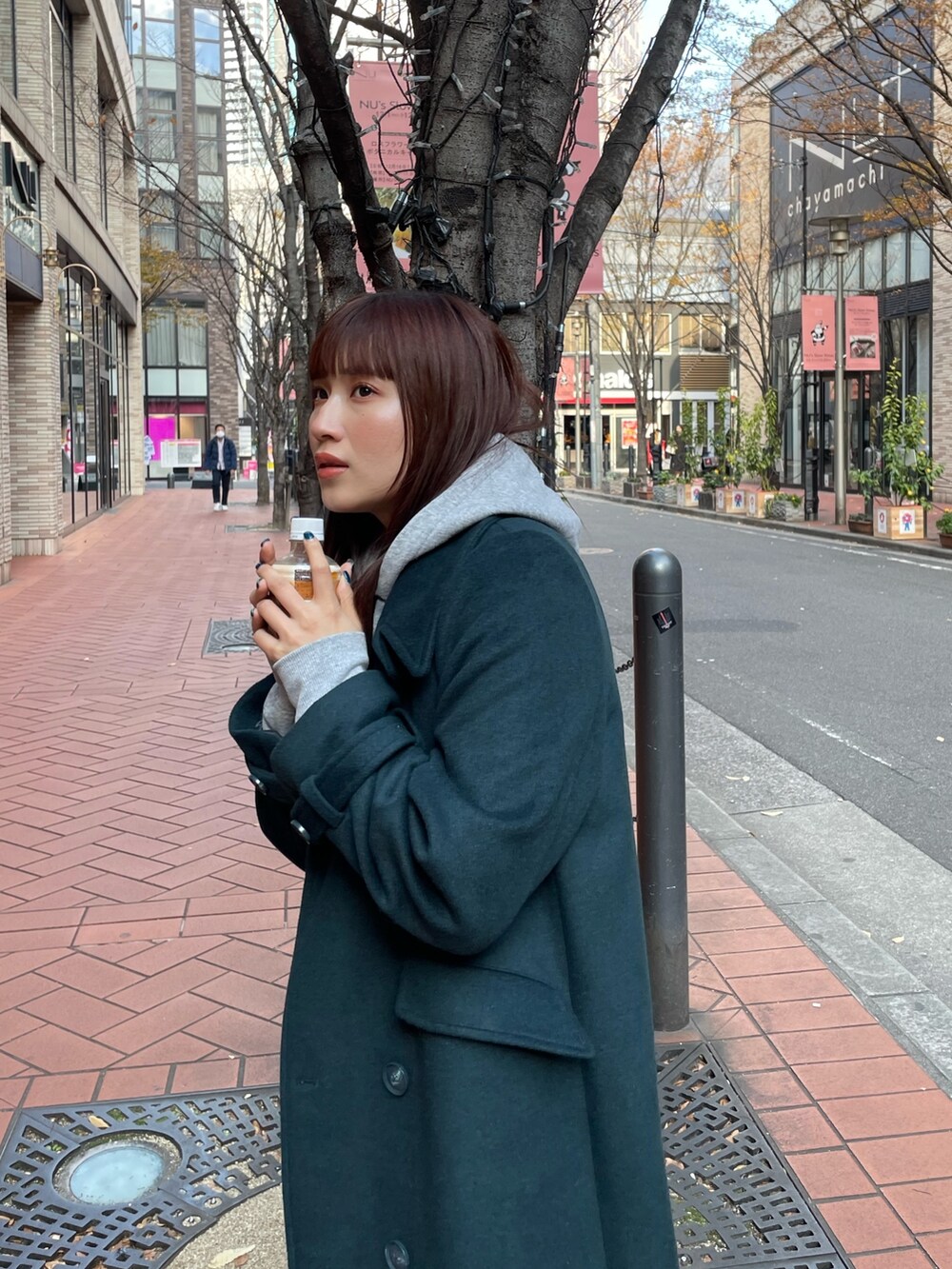 グリーン系のチェスターコートを着用したレディースの冬コーディネートの3枚目の写真