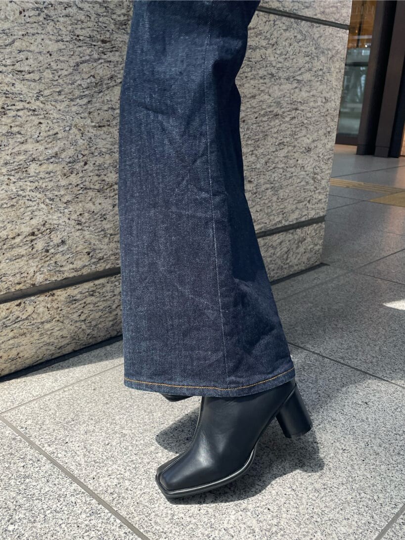 グリーン系のハンドバッグ、ブラック系のブーツ、ブラック系のTシャツ/カットソーを着用したレディースの夏コーディネートの9枚目の写真