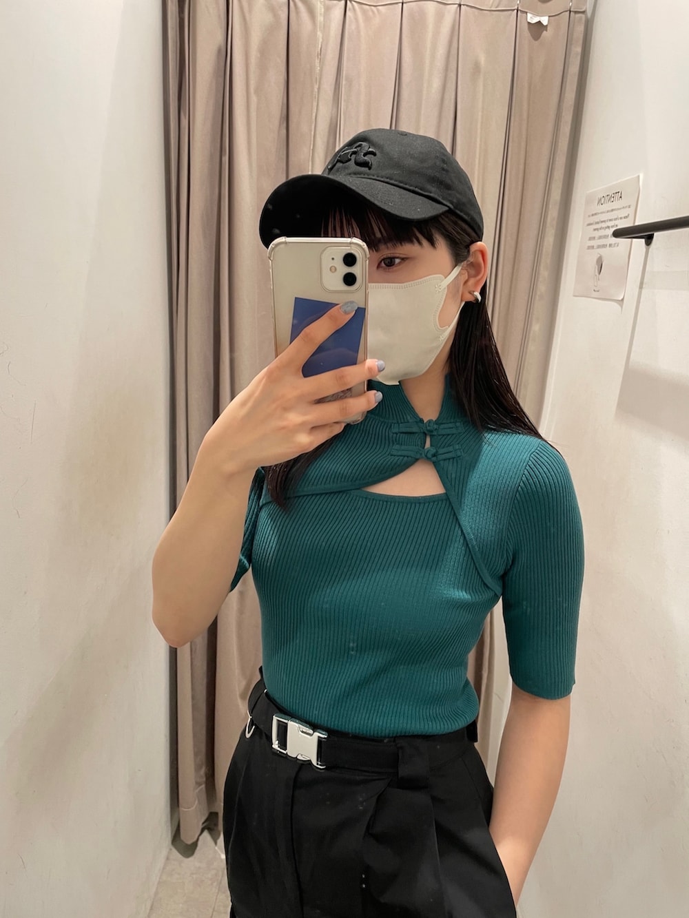 グリーン系のニット/セーター、ブラック系のカーゴパンツ、ブラック系のサンダルを着用したレディースの春コーディネートの2枚目の写真