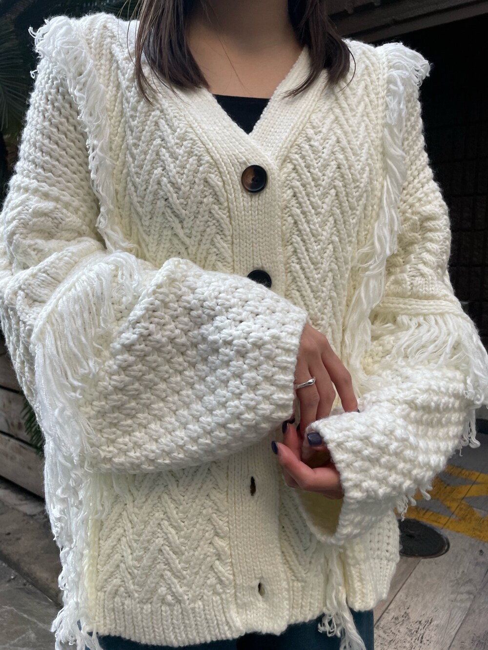ホワイト系のカーディガン/ボレロ、ブルー系のスラックスを着用したレディースの冬コーディネートの7枚目の写真