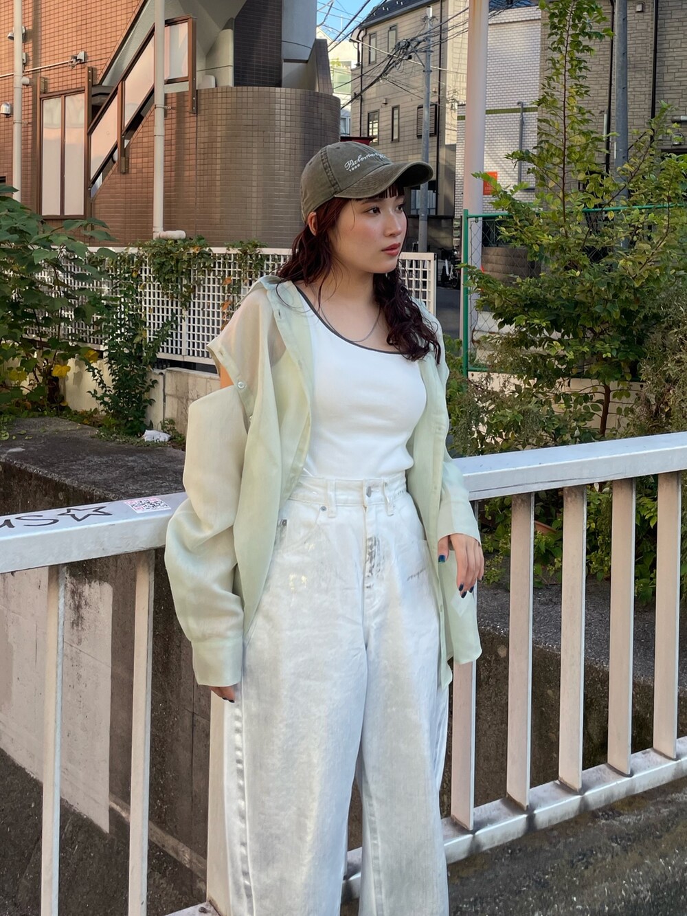 グリーン系のシャツ/ブラウス、ホワイト系のデニムパンツを着用したレディースの冬コーディネートの4枚目の写真