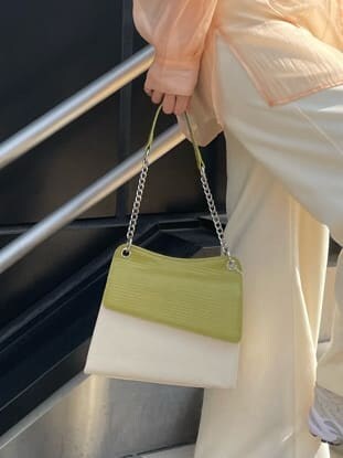 ホワイト系のスラックス、ホワイト系のハンドバッグ、ホワイト系のタンクトップを着用したレディースの春コーディネートの9枚目の写真