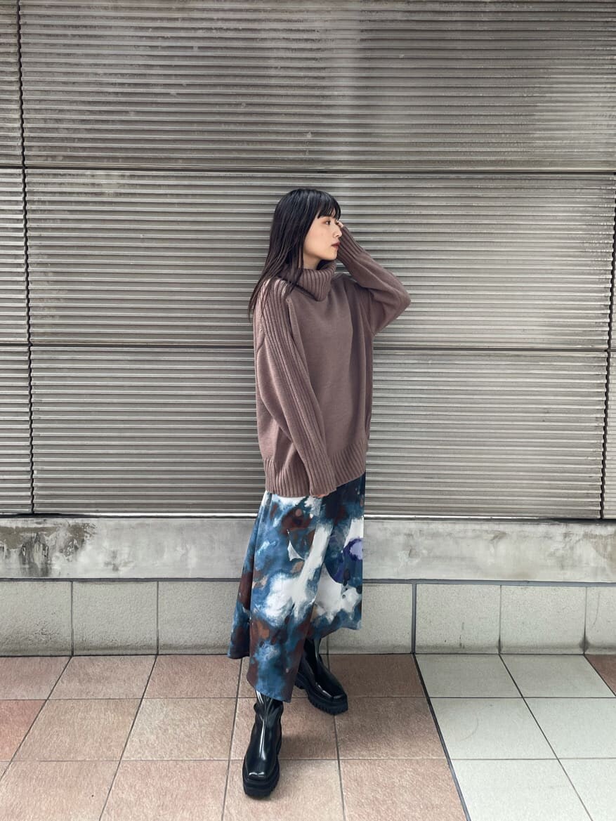 ベージュ系のニット/セーター、ブラック系のダウンジャケット/コート、ブルー系のスカートを着用したレディースの秋コーディネートの3枚目の写真