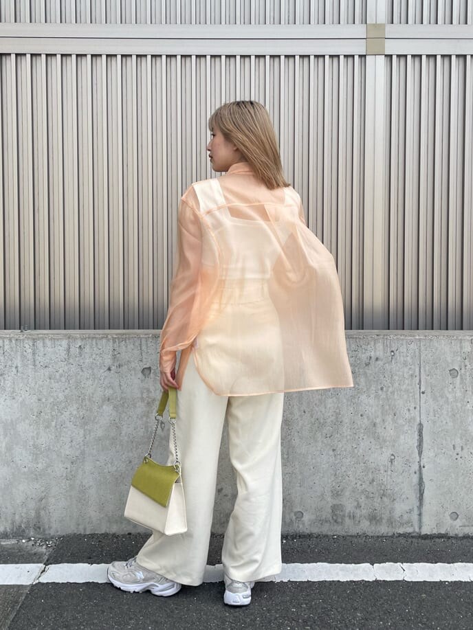 ホワイト系のスラックス、ホワイト系のハンドバッグ、ホワイト系のタンクトップを着用したレディースの春コーディネートの3枚目の写真