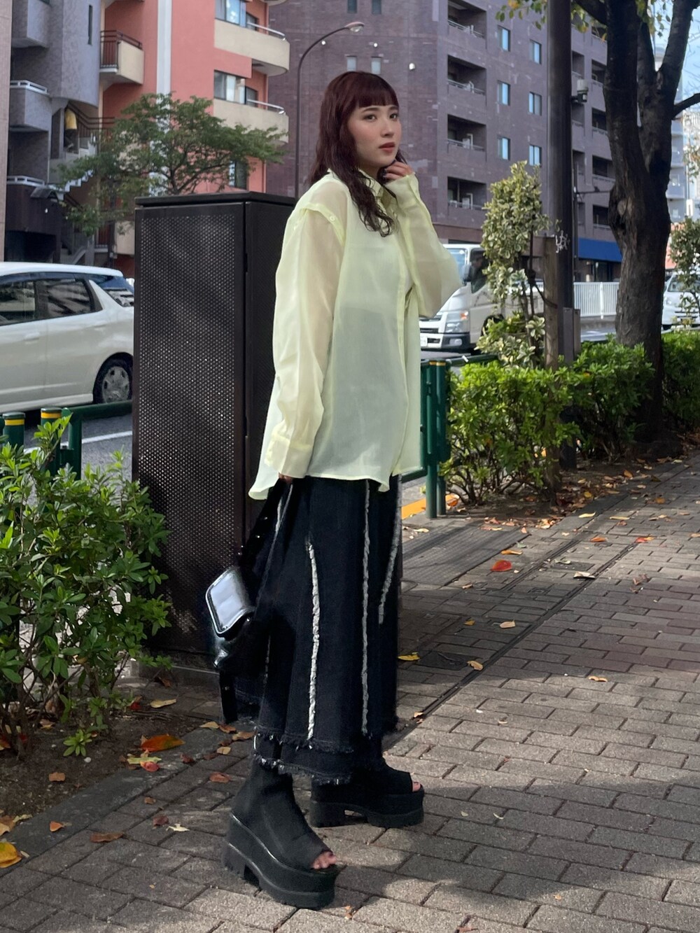 イエロー系のシャツ/ブラウス、ブラック系のデニムスカートを着用したレディースの冬コーディネートの2枚目の写真