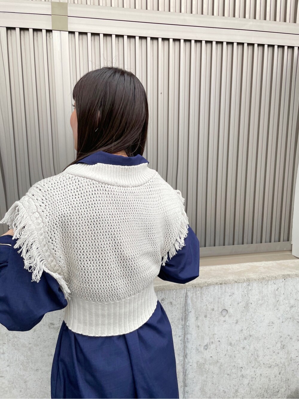 ブルー系のシャツ/ブラウス、ホワイト系のサンダル、グレー系のニット/セーターを着用したレディースの春コーディネートの8枚目の写真