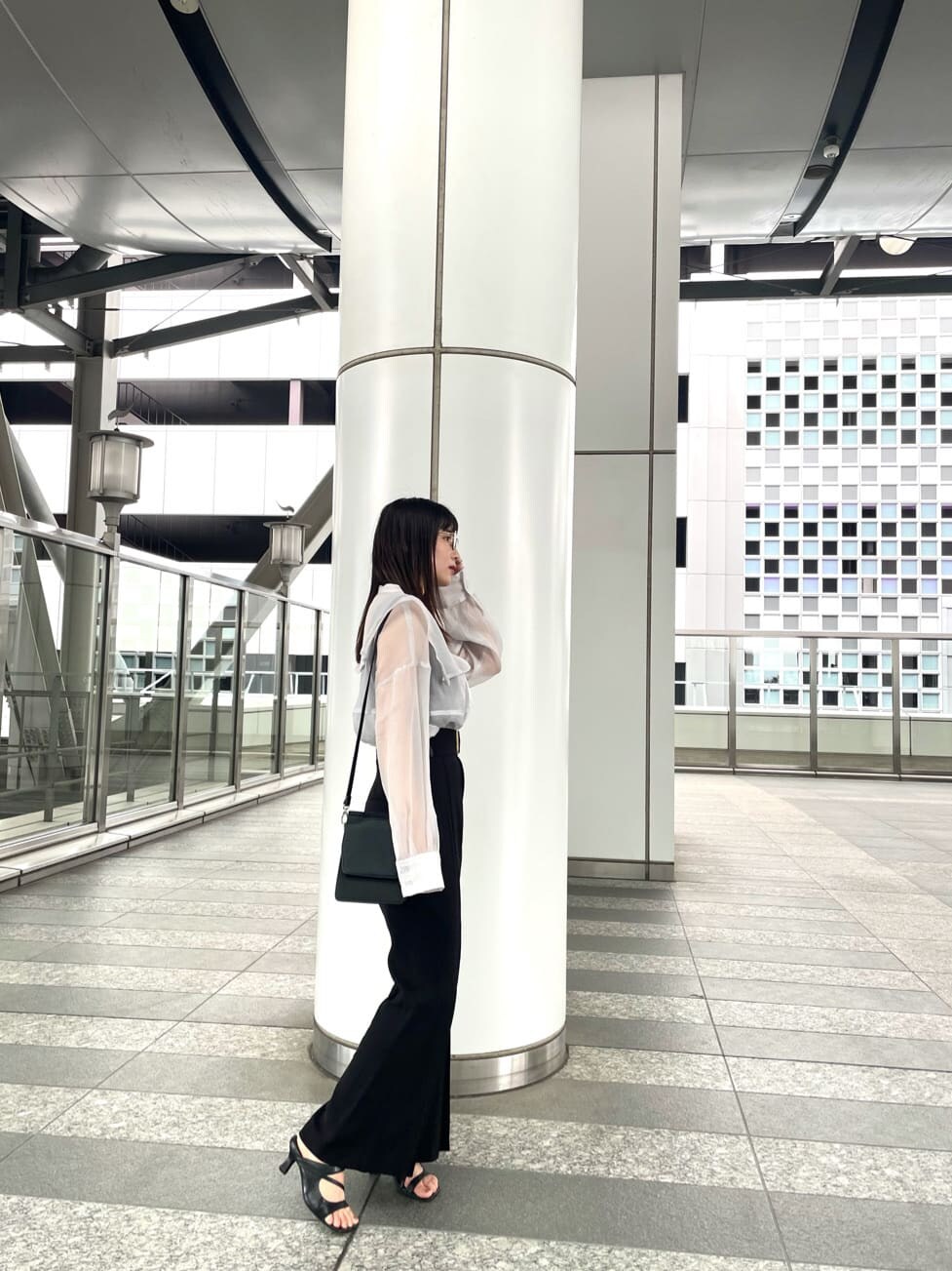 ブラック系のその他パンツ、ブラック系のサンダル、ホワイト系のシャツ/ブラウスを着用したレディースの夏コーディネートの3枚目の写真