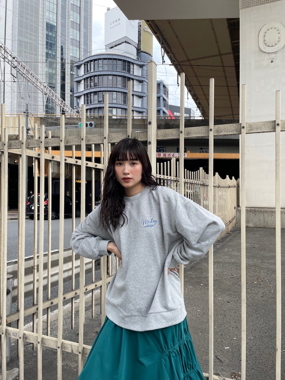 グリーン系のスカート、グレー系のスウェットを着用したレディースの秋コーディネートの2枚目の写真